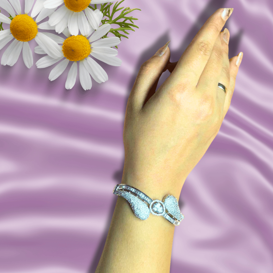 Sparkling rhodium American diamond bracelet with a unique flowing design, set against a luxurious velvet backdrop with delicate pink blossoms, radiating elegance and sophistication.