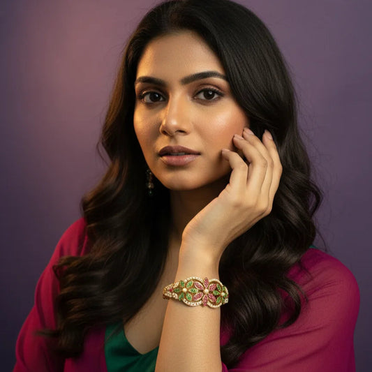 Woman wearing a bracelet with gemstones against a purple background