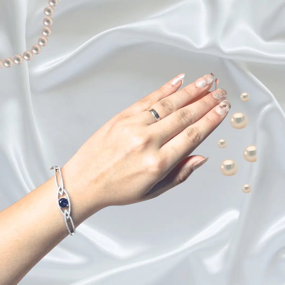 Close-up of silver plated American diamond bangle with blue stone centerpiece