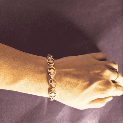 Gold bangle bracelet for women closeup view showing floral details on wrist