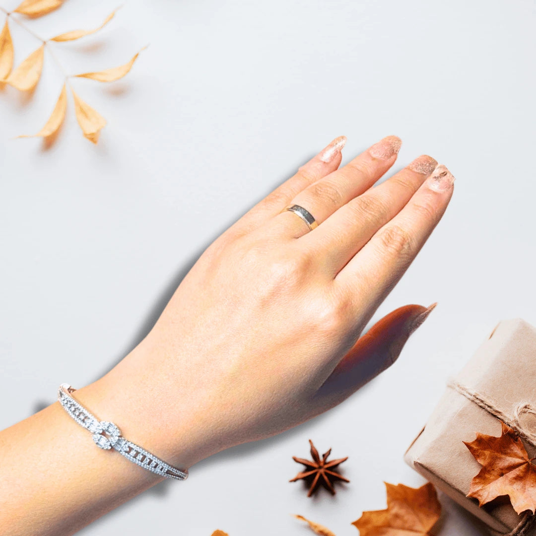 Party wear bracelet in silver with AD stones, elegant on wrist against navy backdrop
